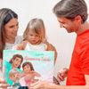 Papá observa cariñosamente a su hija y sostiene su libro personalizado para familias