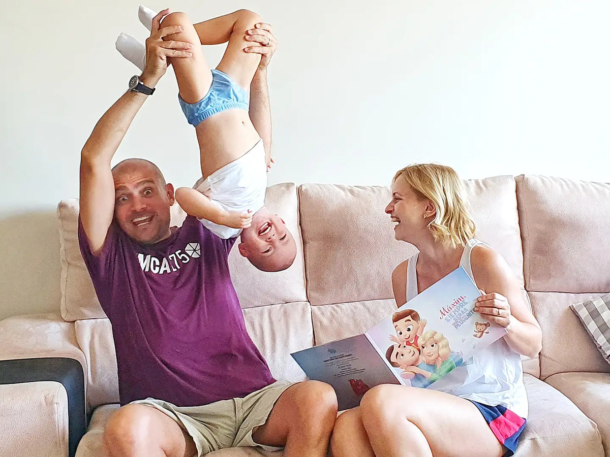 Padres felices y su hijo disfrutando de un libro personalizado protagonizado por ambos padres y su hijo.